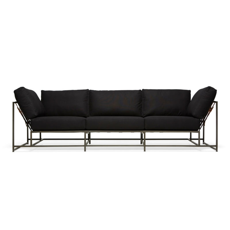 Soft black canvas upholstery atop a steel frame with a blackened finish. The supporting belts are composed of a black cotton webbing, cognac brown leather, and black buckles.